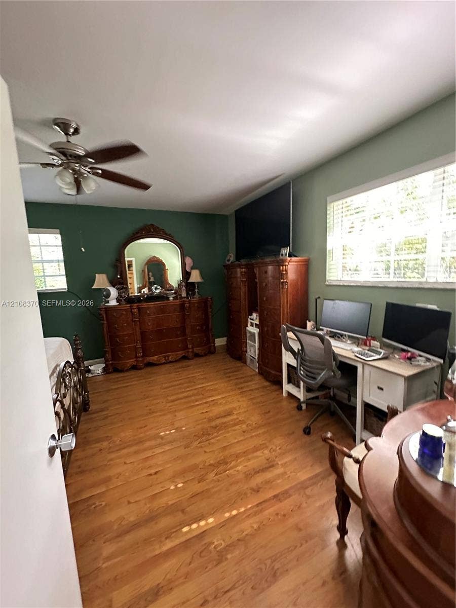 18901 SW 63rd Street, Southwest Ranches, FL 33332 Wood-finish flooring, multi-blade ceiling fan with integrated lighting, and dual windows with horizontal blinds