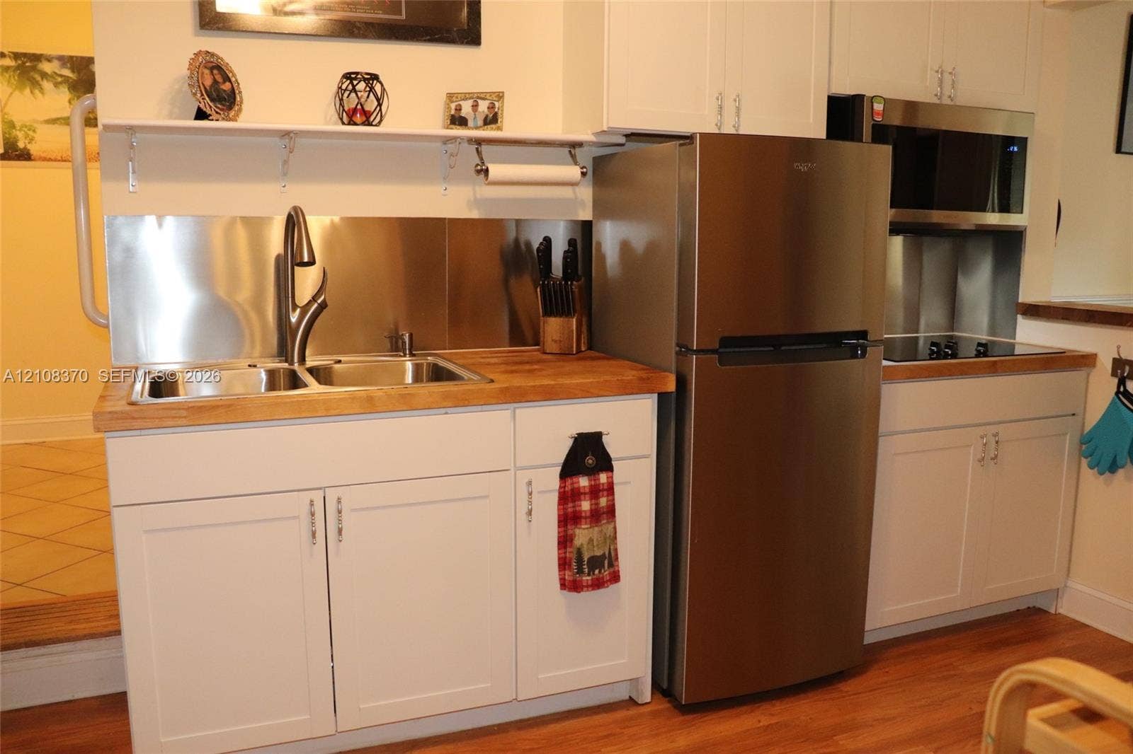 18901 SW 63rd Street, Southwest Ranches, FL 33332 White shaker-style cabinetry, wood-surface countertops, stainless steel appliances, dual-basin stainless steel sink with high-arc faucet, and stainless steel backsplash