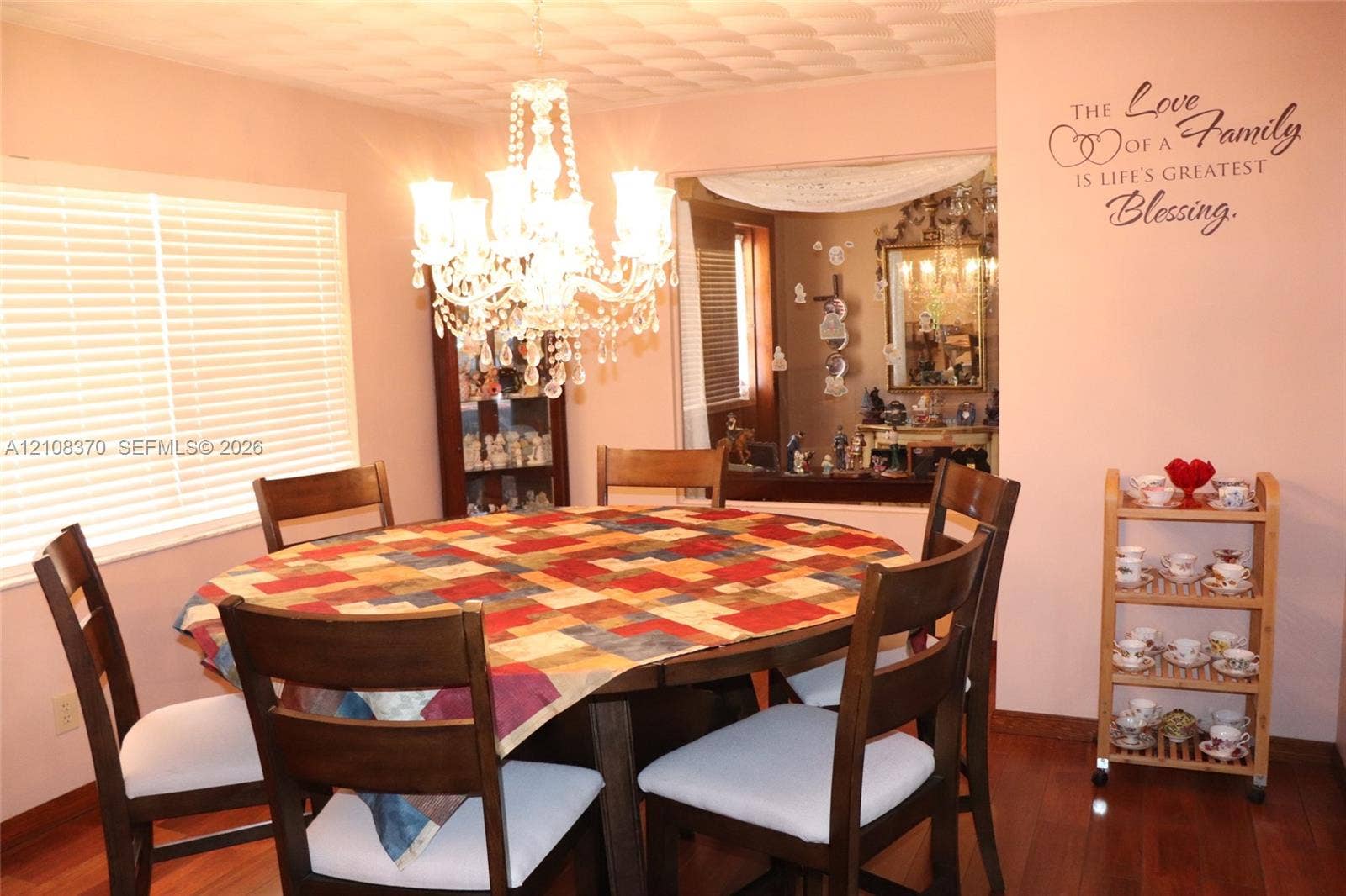18901 SW 63rd Street, Southwest Ranches, FL 33332 Dining area featuring wood-finish flooring, a multi-tiered crystal chandelier, and large window with horizontal blinds