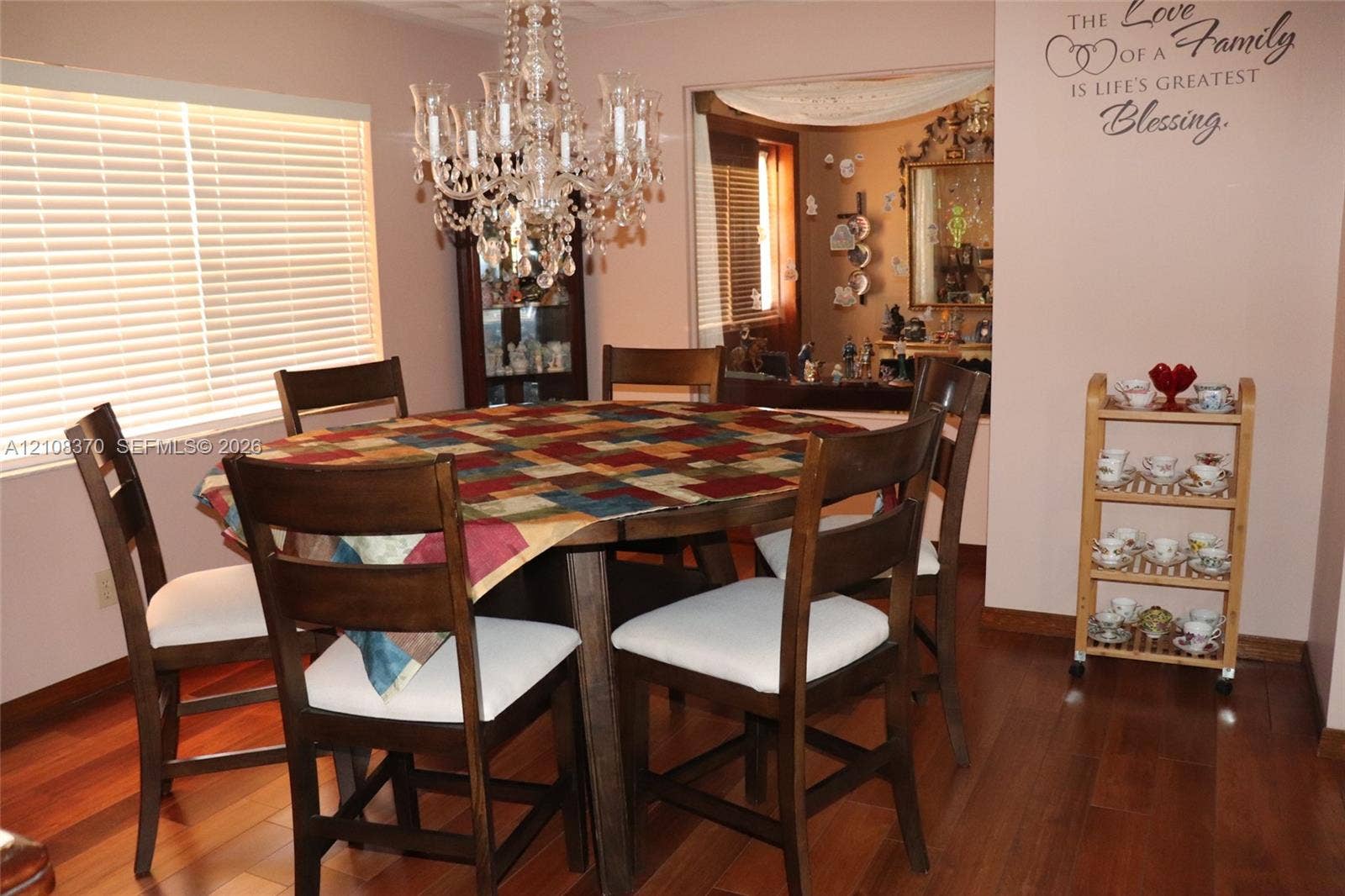 18901 SW 63rd Street, Southwest Ranches, FL 33332 Dining area featuring wood-finish flooring, a multi-tiered crystal chandelier, and windows with horizontal blinds