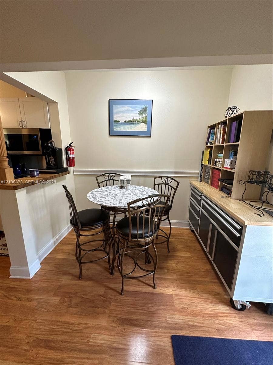 18901 SW 63rd Street, Southwest Ranches, FL 33332 Wood-finish flooring, half-wall partition with a wood-surface counter, and wall-mounted chair rail molding