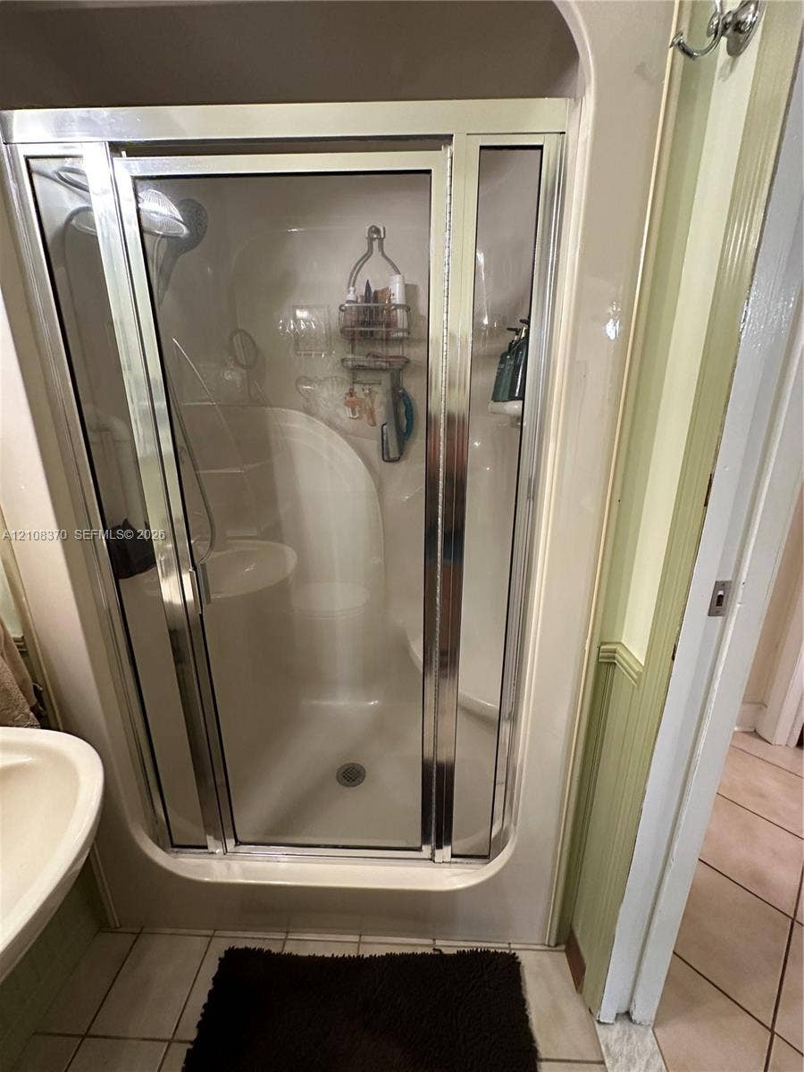 18901 SW 63rd Street, Southwest Ranches, FL 33332 Shower enclosure featuring a chrome-framed glass door, integrated molded shower surround, and a wall-mounted shower fixture