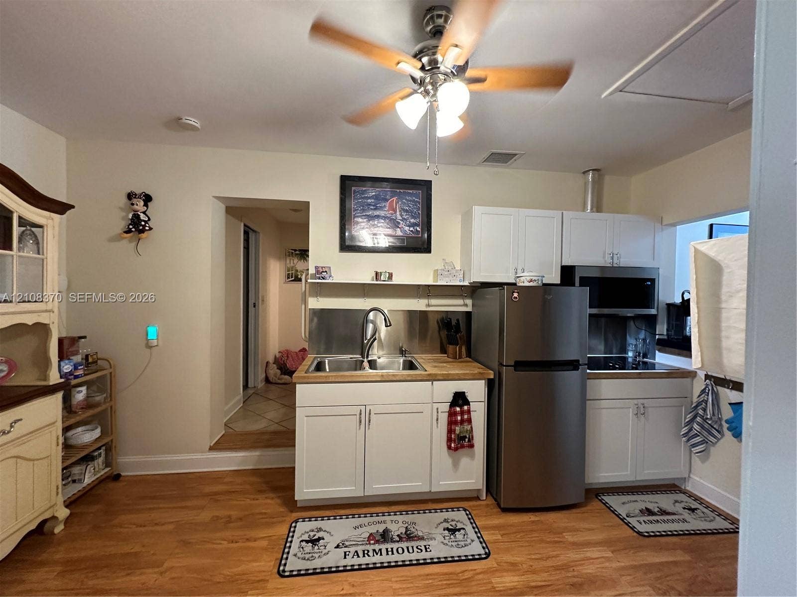 18901 SW 63rd Street, Southwest Ranches, FL 33332 Kitchen featuring white shaker-style cabinetry, wood-finish countertops, a stainless steel undermount sink with a gooseneck faucet, stainless steel appliances, and wood-finish flooring