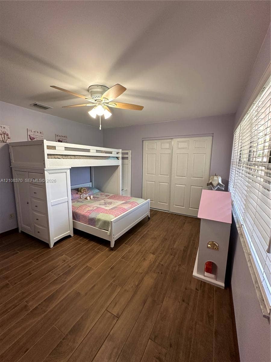 18901 SW 63rd Street, Southwest Ranches, FL 33332 Wood-finish plank flooring, ceiling fan with integrated light fixture, and dual-panel sliding closet doors