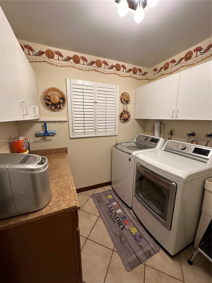 18901 SW 63rd Street, Southwest Ranches, FL 33332 Laundry room featuring white shaker-style wall cabinetry, a laminate countertop, tile flooring, and a window with plantation-style shutters