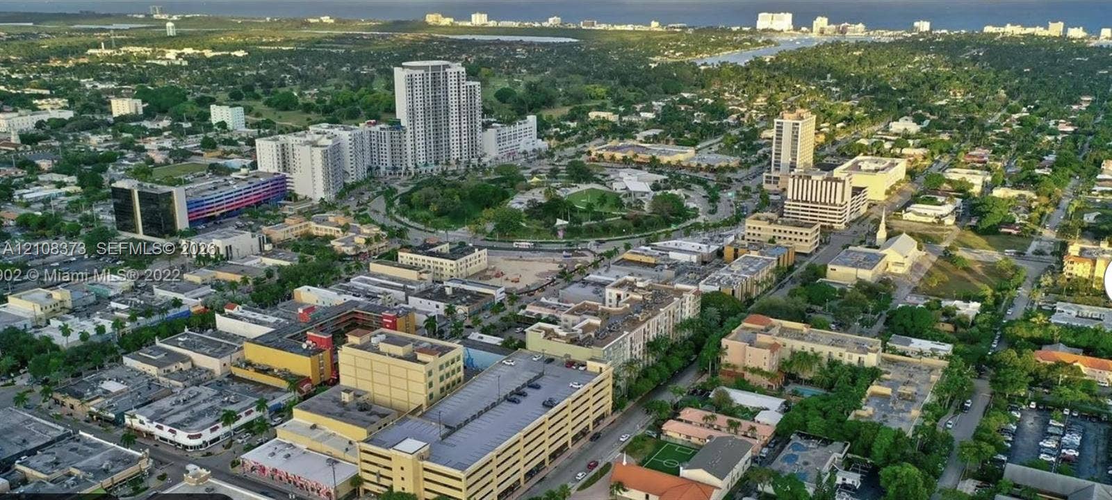 1900 Van Buren Street, #411B, Hollywood, FL 33020 Aerial perspective of an urban district featuring high-rise architecture, mixed-use commercial buildings, dense mature tree canopy, and established thoroughfare infrastructure