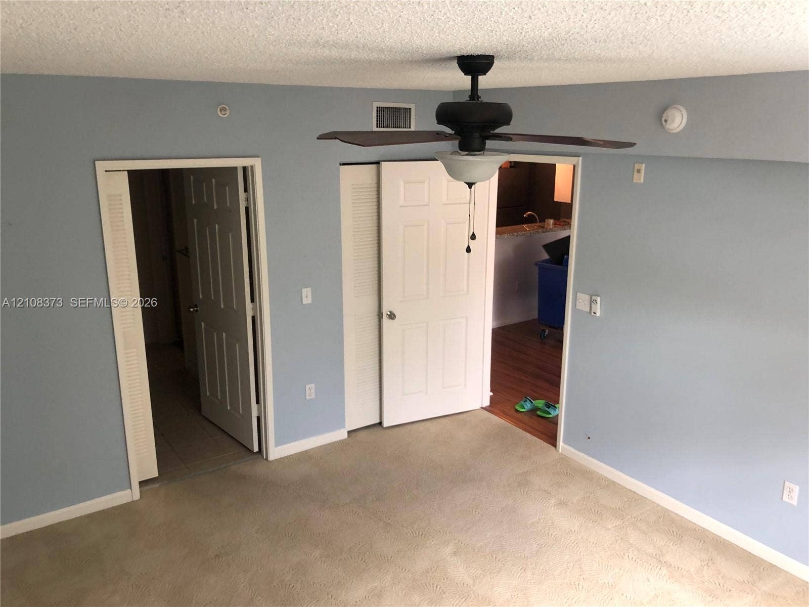 1900 Van Buren Street, #411B, Hollywood, FL 33020 Neutral-toned wall-to-wall carpeting, ceiling-mounted paddle fan with integrated lighting, and multiple paneled interior doors