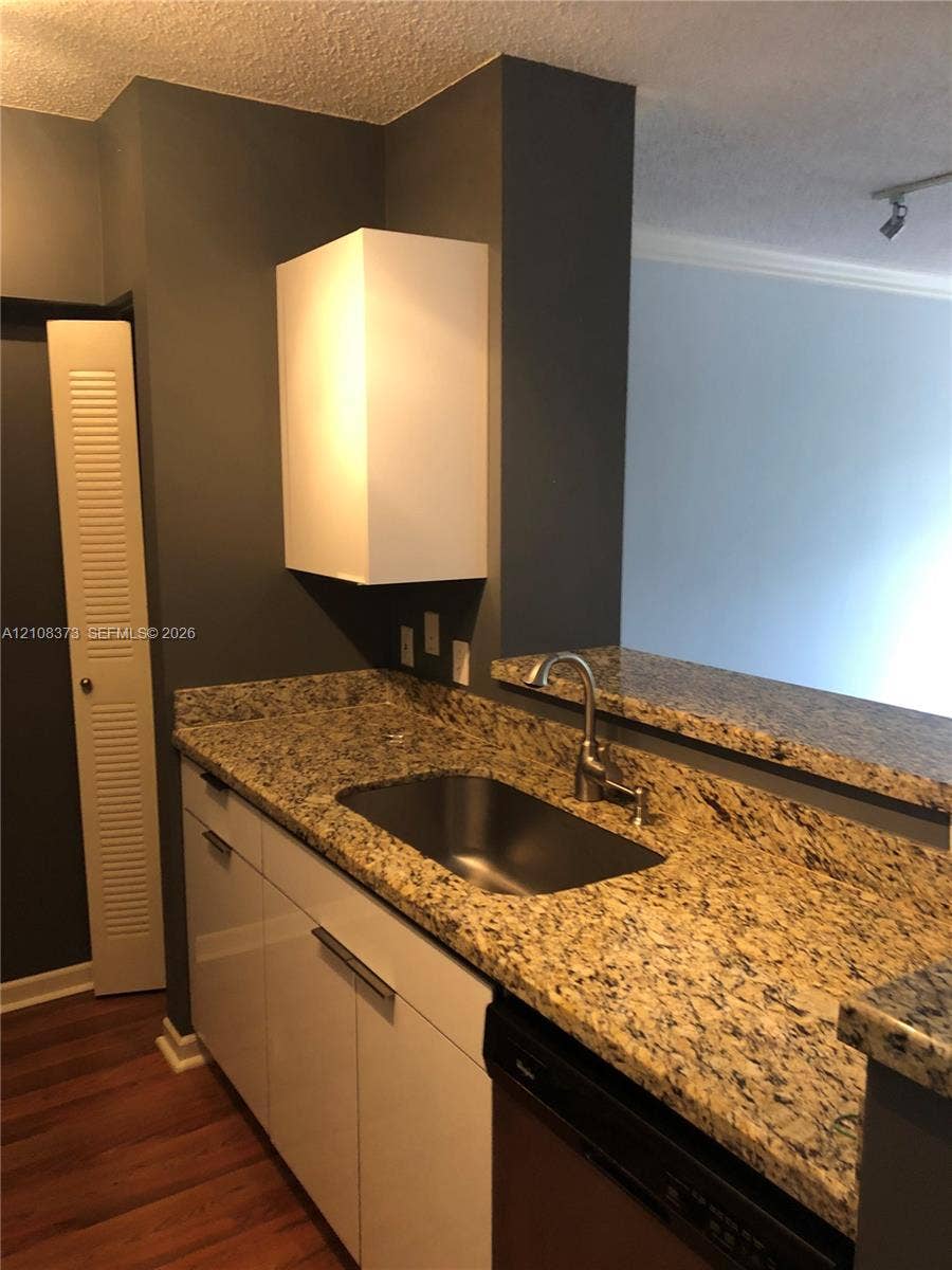 1900 Van Buren Street, #411B, Hollywood, FL 33020 Kitchen featuring stone countertops, stainless steel undermount sink, gooseneck faucet, high-gloss white cabinetry, and wood-finish flooring
