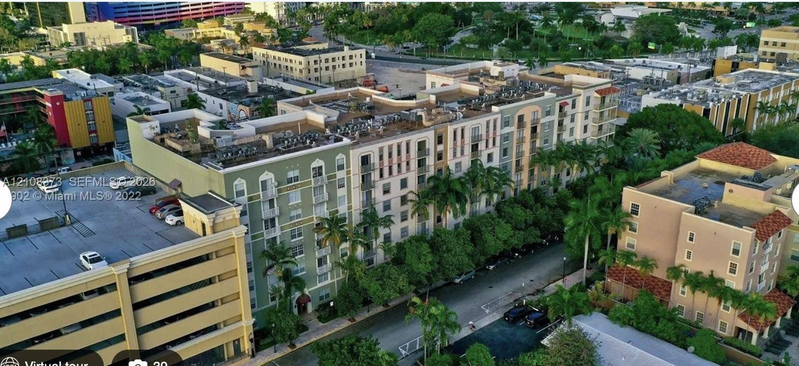 1900 Van Buren Street, #411B, Hollywood, FL 33020 Multi-story building featuring an arched facade, decorative balconies, stucco exterior, and integrated parking structure
