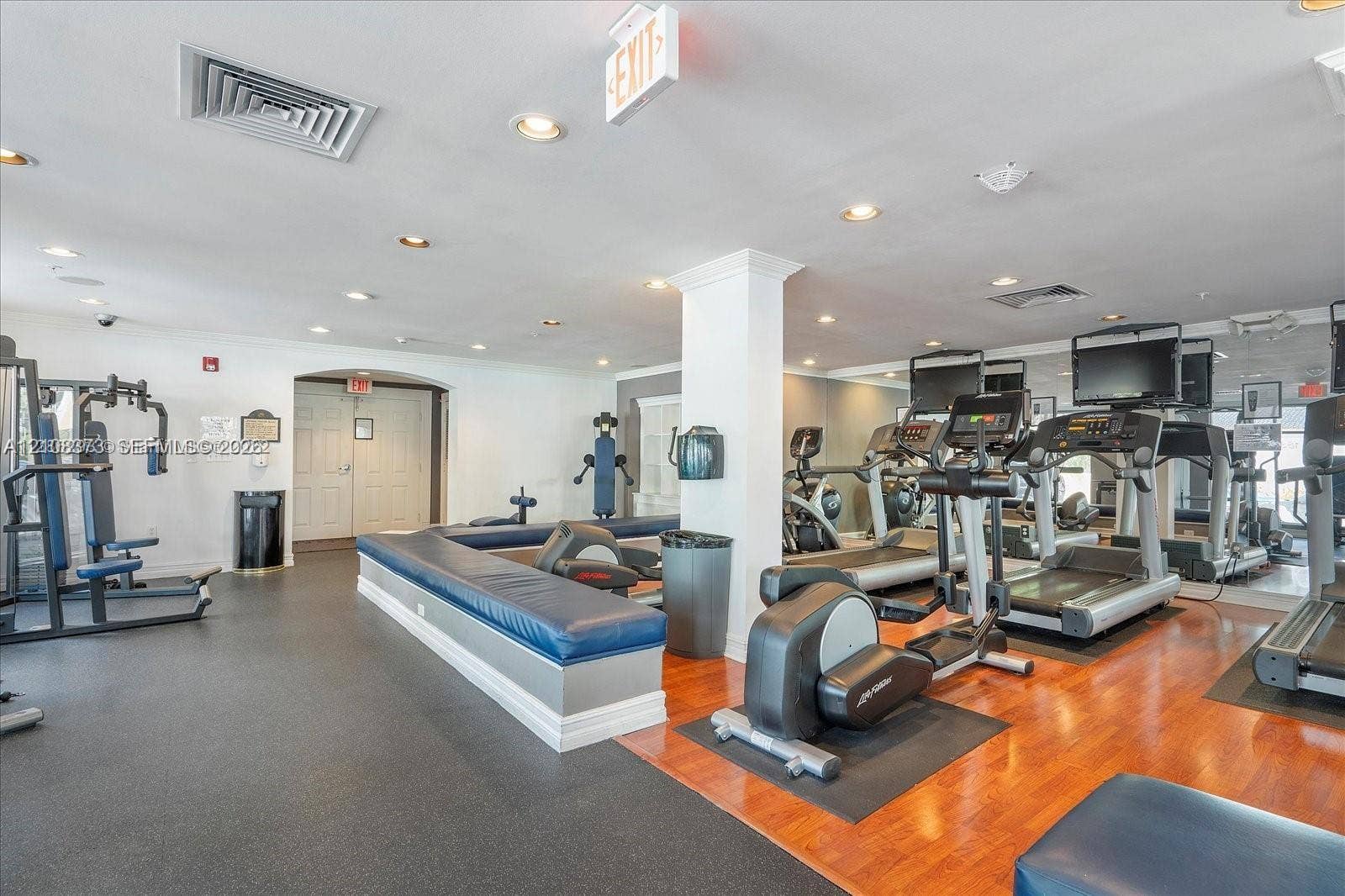1900 Van Buren Street, #411B, Hollywood, FL 33020 Fitness center featuring recessed lighting, expansive wall-to-wall mirrors, wood-finish flooring, and a built-in upholstered bench