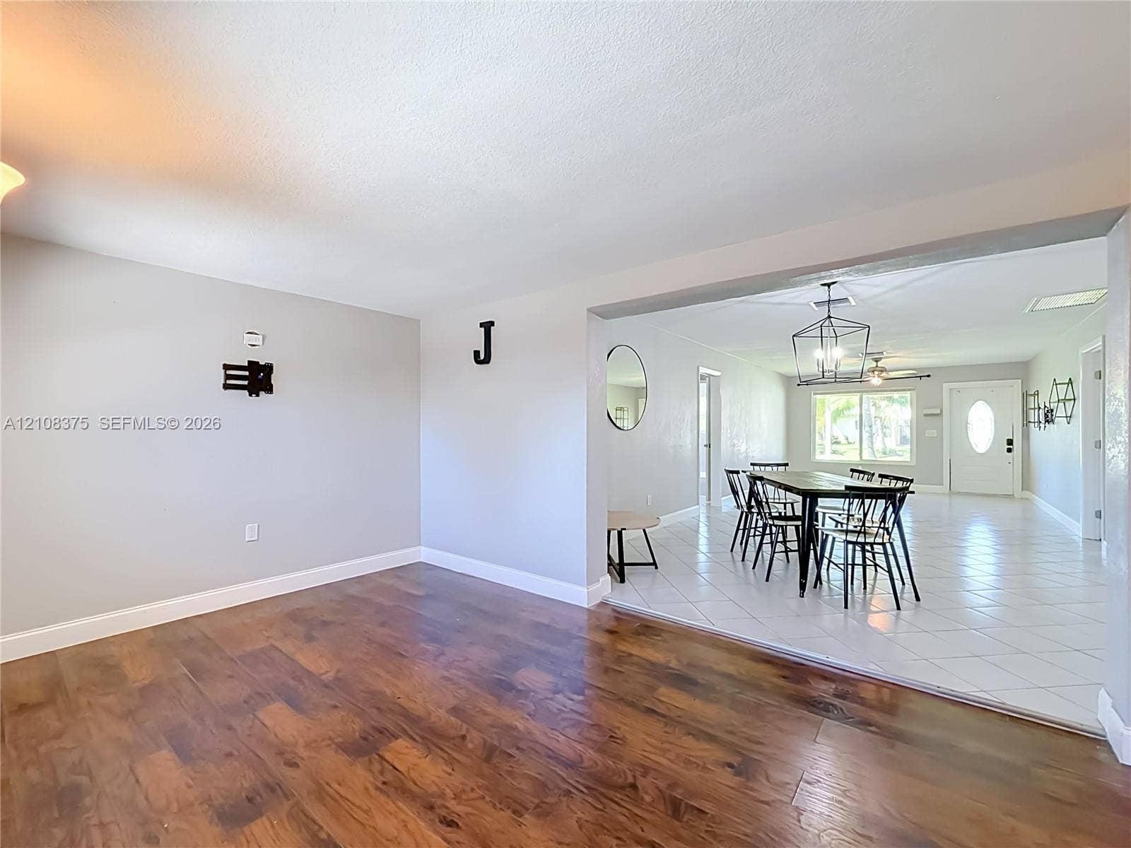 3330 NE 14th Terrace, Pompano Beach, FL 33064 Wood-finish flooring, white ceramic tile flooring, geometric metal pendant lighting, and neutral wall tones