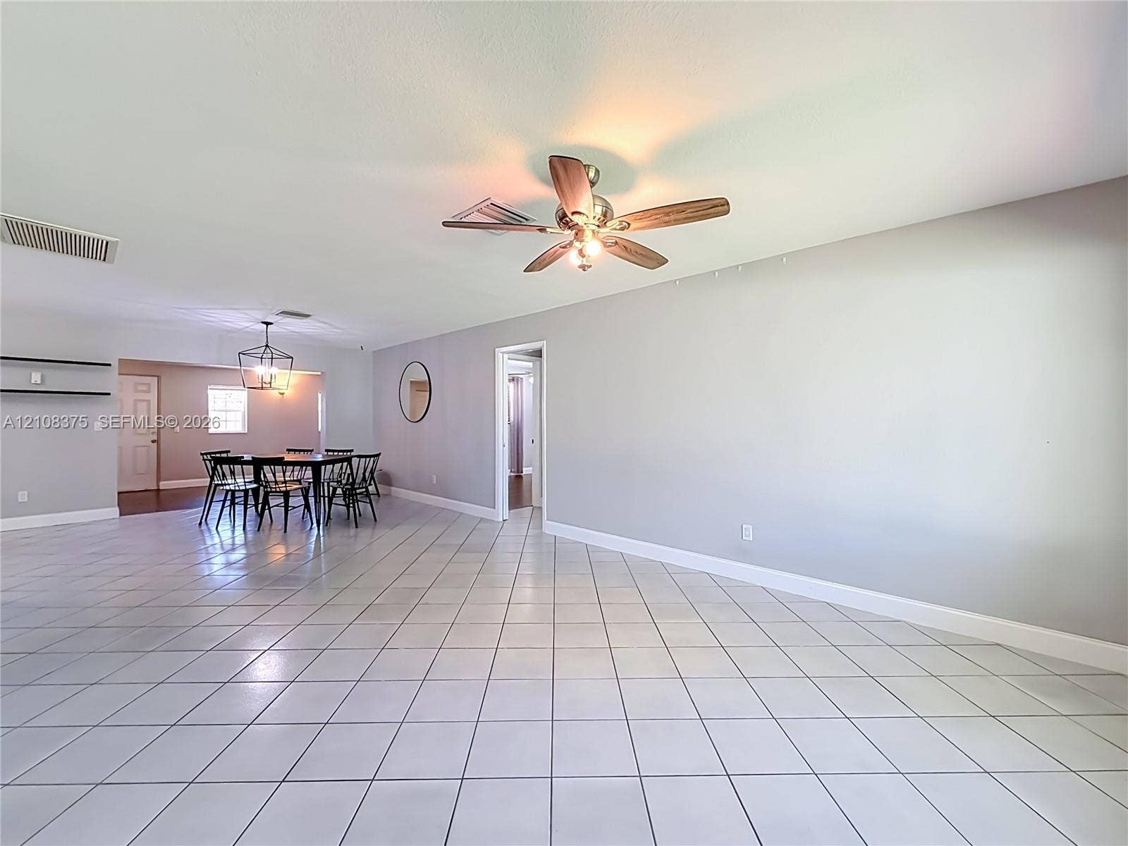 3330 NE 14th Terrace, Pompano Beach, FL 33064 Large living area featuring neutral-toned tile flooring, recessed lighting, and a ceiling fan with integrated lighting
