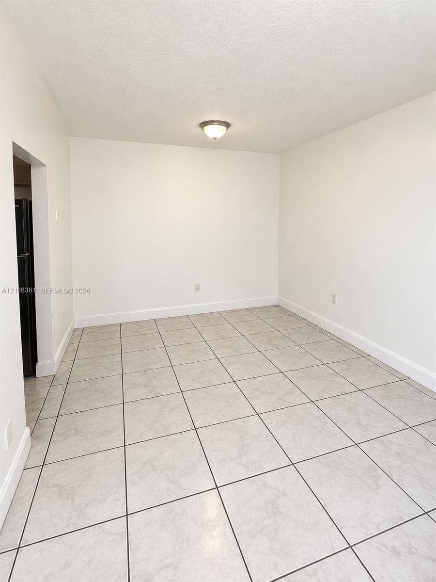 621 NW 177th Street, #101, Miami Gardens, Miami Gardens, FL 33169 Neutral-toned ceramic tile flooring, smooth white wall finishes, and glass sliding door access to exterior space