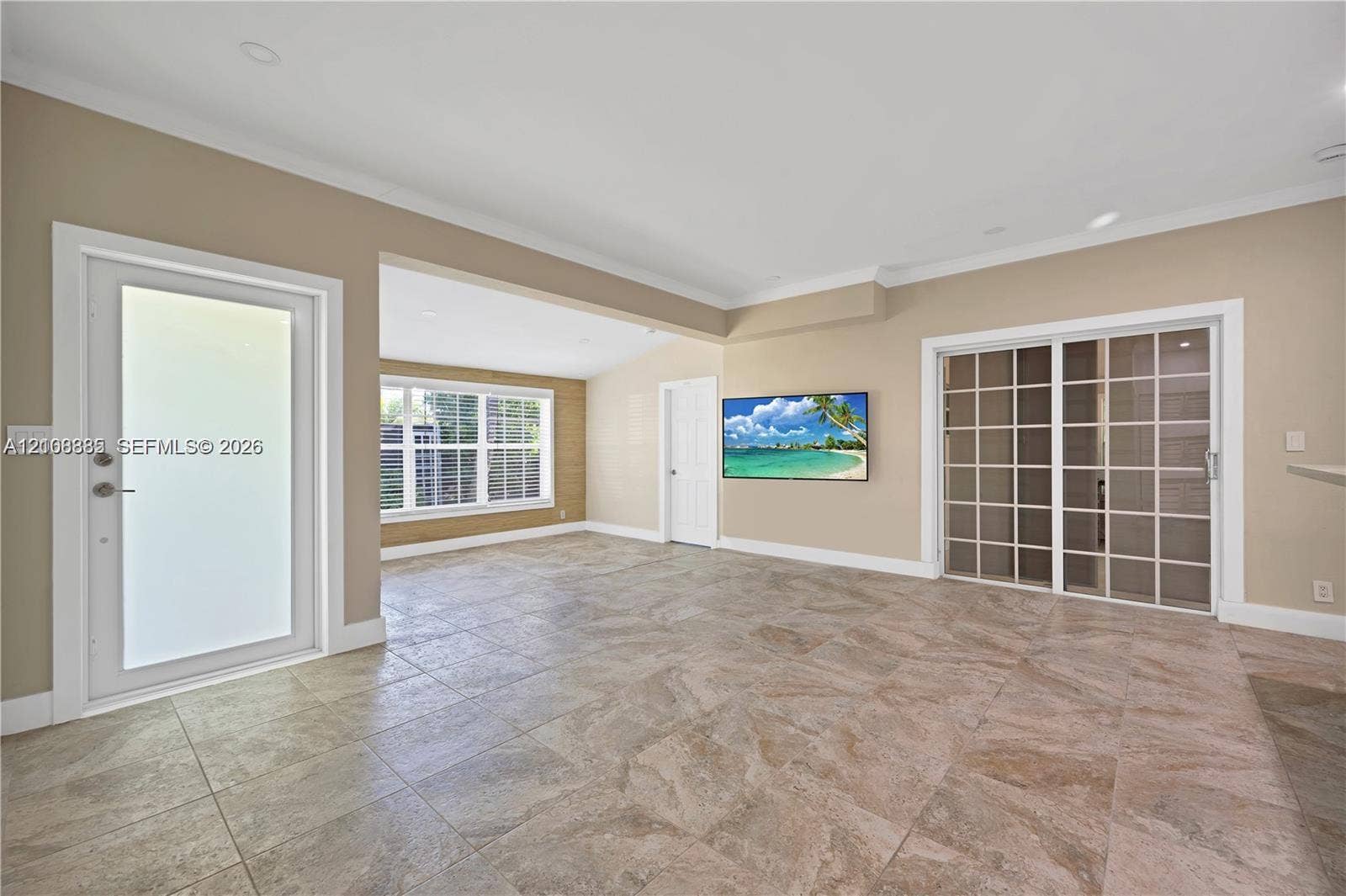 818 NE 3rd Street, Hallandale Beach, Hallandale Beach, FL 33009 Open-concept interior featuring large-format tile flooring, multi-pane glass sliding doors, recessed ceiling lighting, and a frosted glass entry door