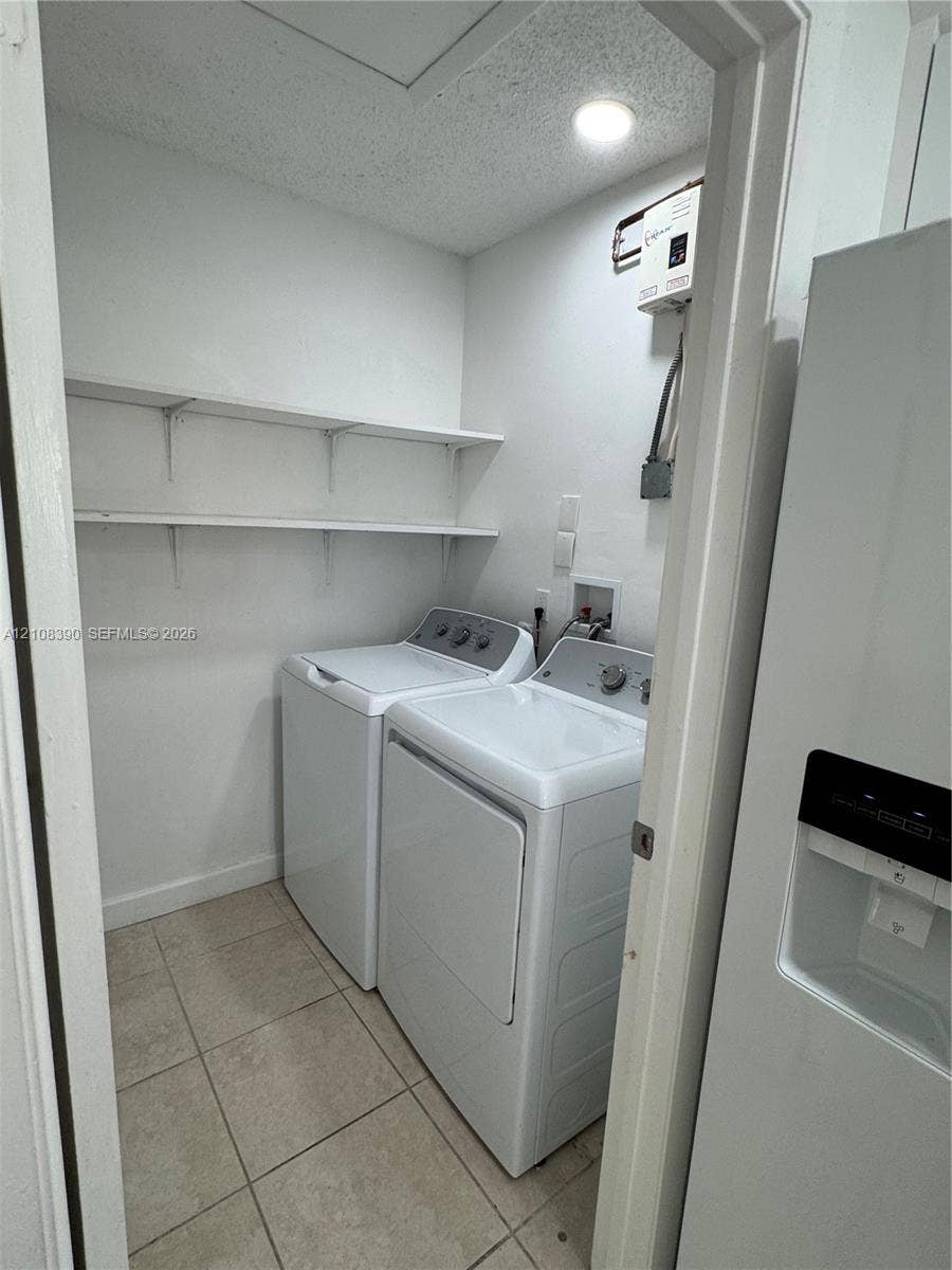 18346 NW 68th Avenue, #K, Hialeah, Hialeah, FL 33015 Laundry closet featuring tile flooring, built-in shelving, and dedicated hookups for a washer and dryer
