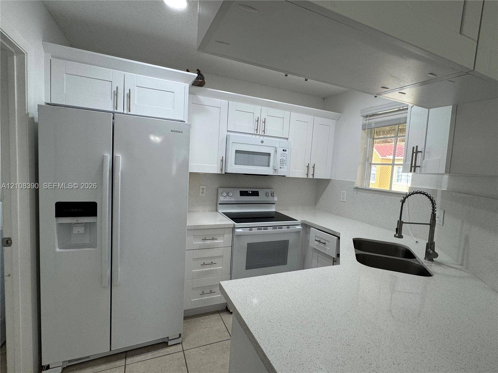 18346 NW 68th Avenue, #K, Hialeah, Hialeah, FL 33015 Kitchen featuring white Shaker-style cabinetry, quartz countertops, a dual-basin undermount sink with a gooseneck faucet, a built-in microwave, and tile flooring