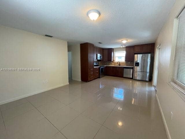 18233 Oleta Drive, #18233, North Miami Beach, North Miami Beach, FL 33160 Kitchen featuring dark wood cabinetry, stainless steel appliances, and large-format tile flooring