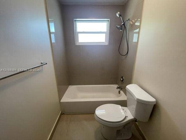 18233 Oleta Drive, #18233, North Miami Beach, North Miami Beach, FL 33160 Full bathroom featuring a white porcelain tub and shower combination, wall-mounted handheld shower fixture, single-hung window, and a standard-height toilet