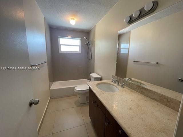 18233 Oleta Drive, #18233, North Miami Beach, North Miami Beach, FL 33160 Bathroom featuring a stone-topped vanity with an integrated basin, large wall-mounted mirror, light-colored tile flooring, and a combined tub and shower unit