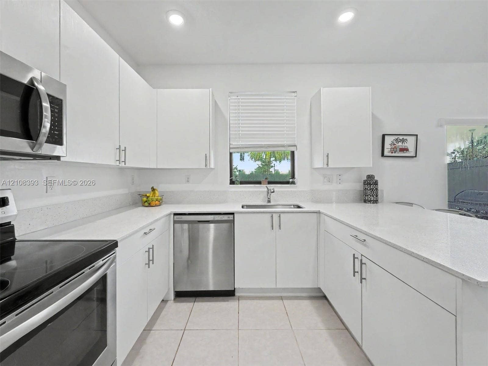 Kitchen featuring white cabinetry, solid-surface countertops, recessed lighting, and stainless steel appliances