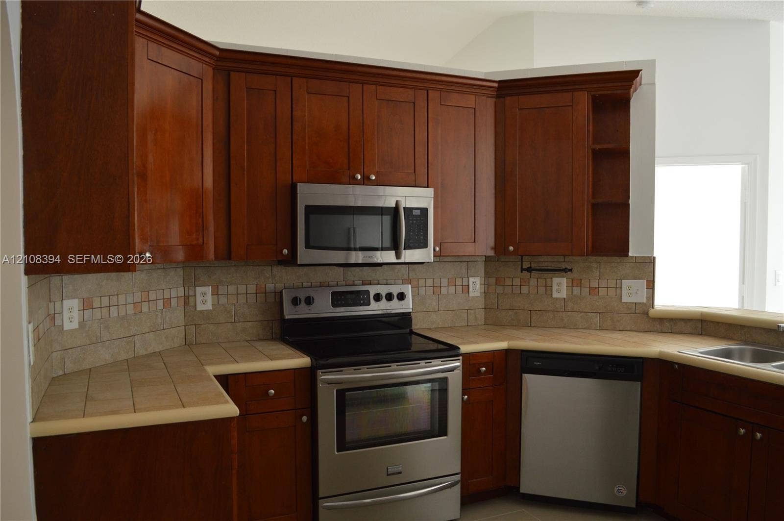 14781 SW 156th Avenue, Miami, Miami, FL 33196 Kitchen featuring wood cabinetry, tiled countertops, stainless steel appliances, and a decorative tile backsplash
