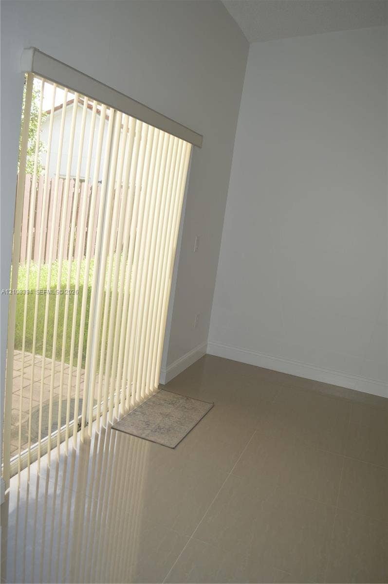 14781 SW 156th Avenue, Miami, Miami, FL 33196 Sliding glass door with vertical blinds, neutral tile flooring, and exterior paver patio