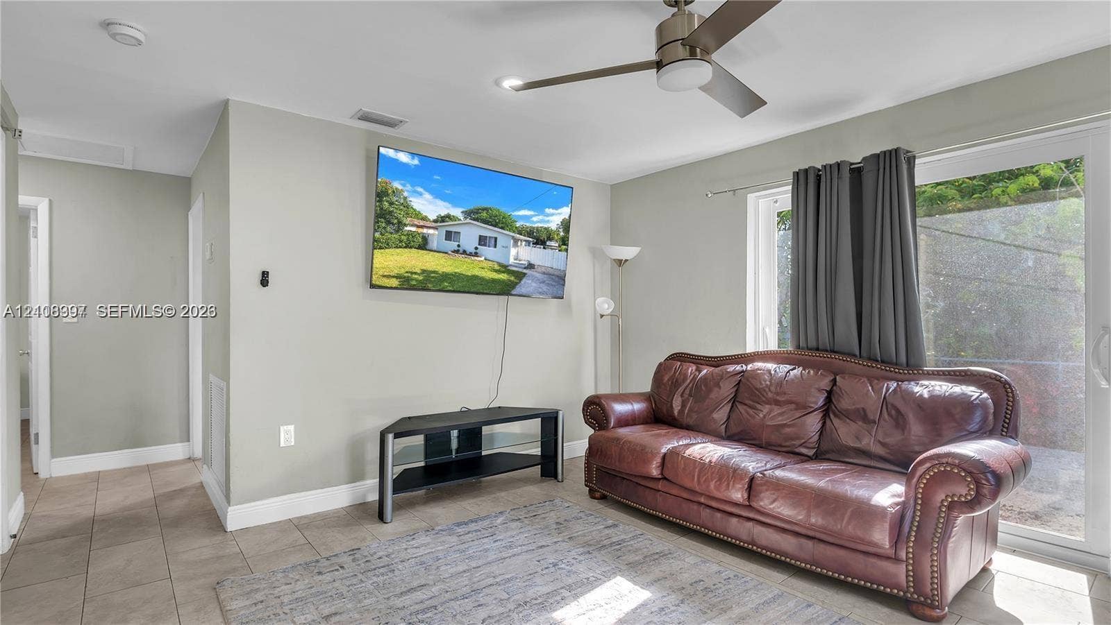 Neutral-toned walls, tile flooring, and a ceiling fan with integrated lighting