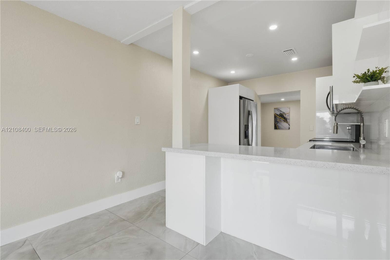2551 SW 53rd Avenue, West Park, West Park, FL 33023 Kitchen featuring white cabinetry, quartz countertops, a stainless steel undermount sink with a gooseneck faucet, large-format tile flooring, and recessed ceiling lighting