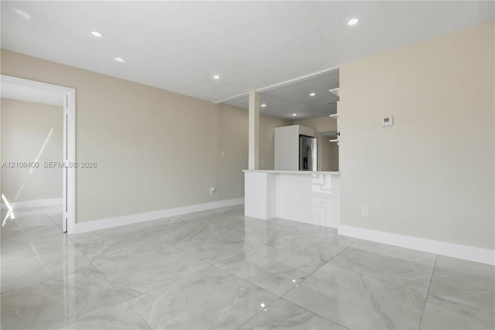 2551 SW 53rd Avenue, West Park, West Park, FL 33023 Large-format tile flooring, neutral wall tones, recessed lighting, and a breakfast bar with stone-surfaced countertop