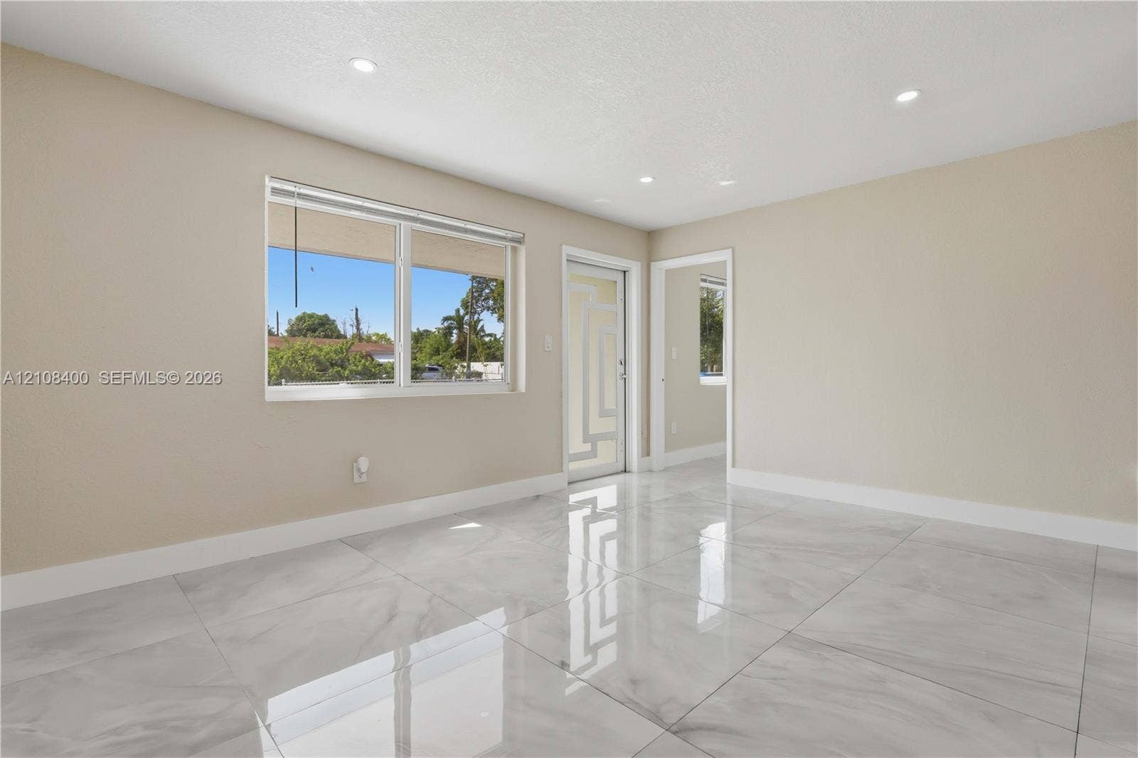 2551 SW 53rd Avenue, West Park, West Park, FL 33023 Large-format polished tile flooring, recessed ceiling lighting, and geometric-patterned glass entry door