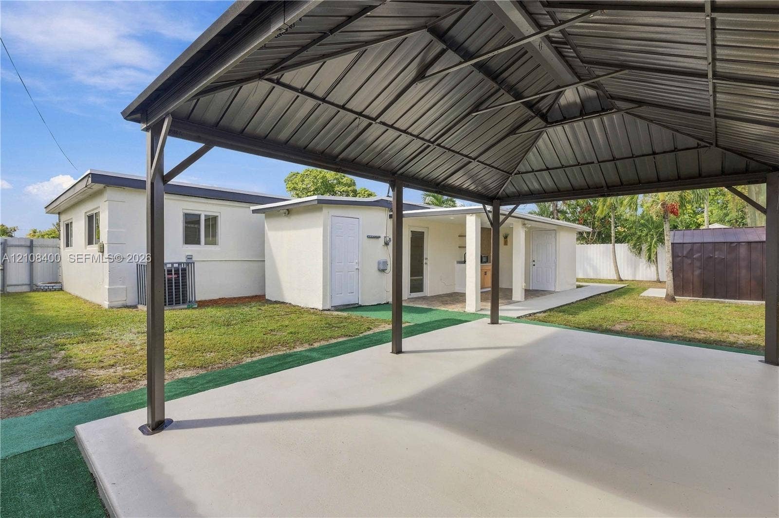 2551 SW 53rd Avenue, West Park, West Park, FL 33023 Covered metal-roofed patio with concrete flooring, open-air structure, and fenced backyard