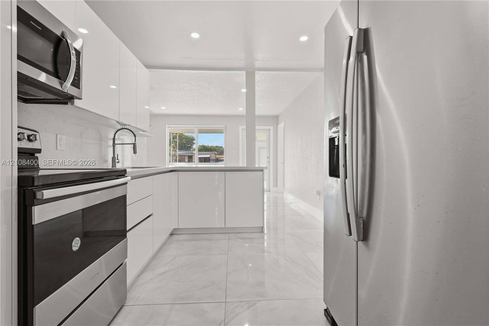 2551 SW 53rd Avenue, West Park, West Park, FL 33023 Kitchen featuring high-gloss white cabinetry, stainless steel appliances, recessed lighting, and large-format tile flooring