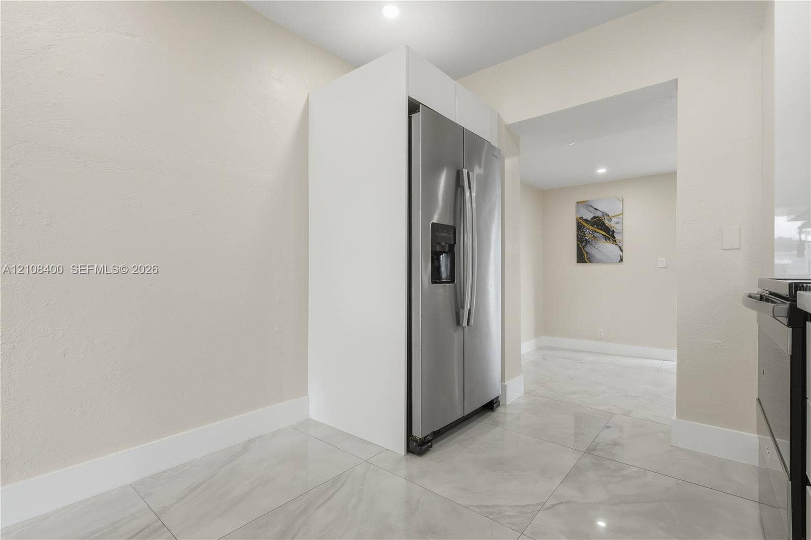 2551 SW 53rd Avenue, West Park, West Park, FL 33023 Stainless steel side-by-side refrigerator, white built-in cabinetry surround, and large-format tile flooring