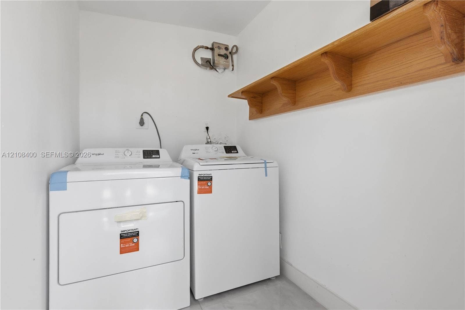 2551 SW 53rd Avenue, West Park, West Park, FL 33023 Dedicated utility space featuring a wall-mounted wood-finish shelving unit