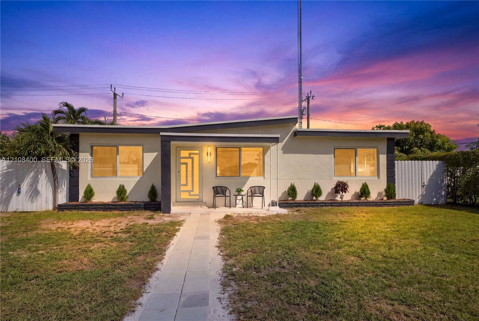 2551 SW 53rd Avenue, West Park, West Park, FL 33023 Single-story exterior featuring a low-slope roof, stucco siding, geometric glass-panel front door, and a concrete walkway