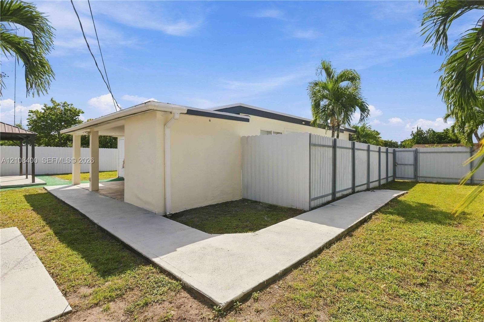 2551 SW 53rd Avenue, West Park, West Park, FL 33023 Backyard featuring a covered concrete patio, perimeter vinyl fencing, and a concrete pathway