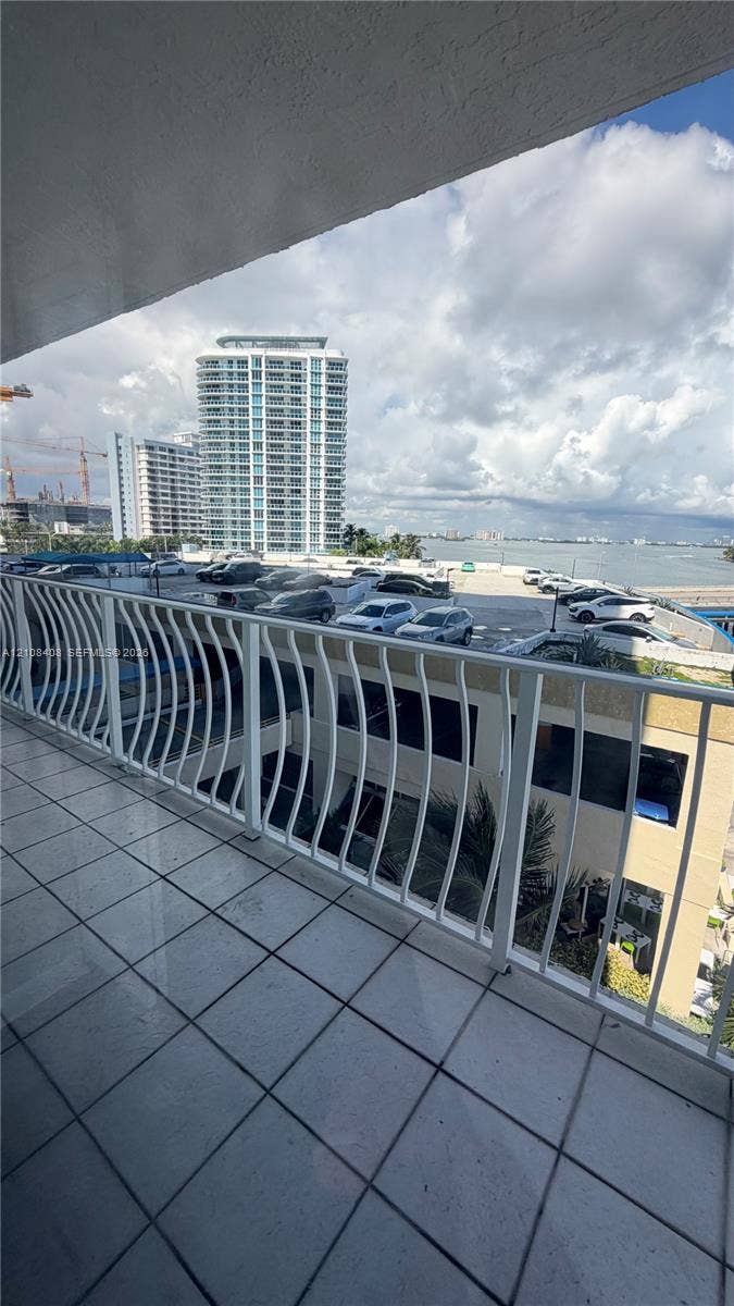 7601 E Treasure Drive, #618, North Bay Village, North Bay Village, FL 33141 Covered balcony featuring white metal railings and tiled flooring