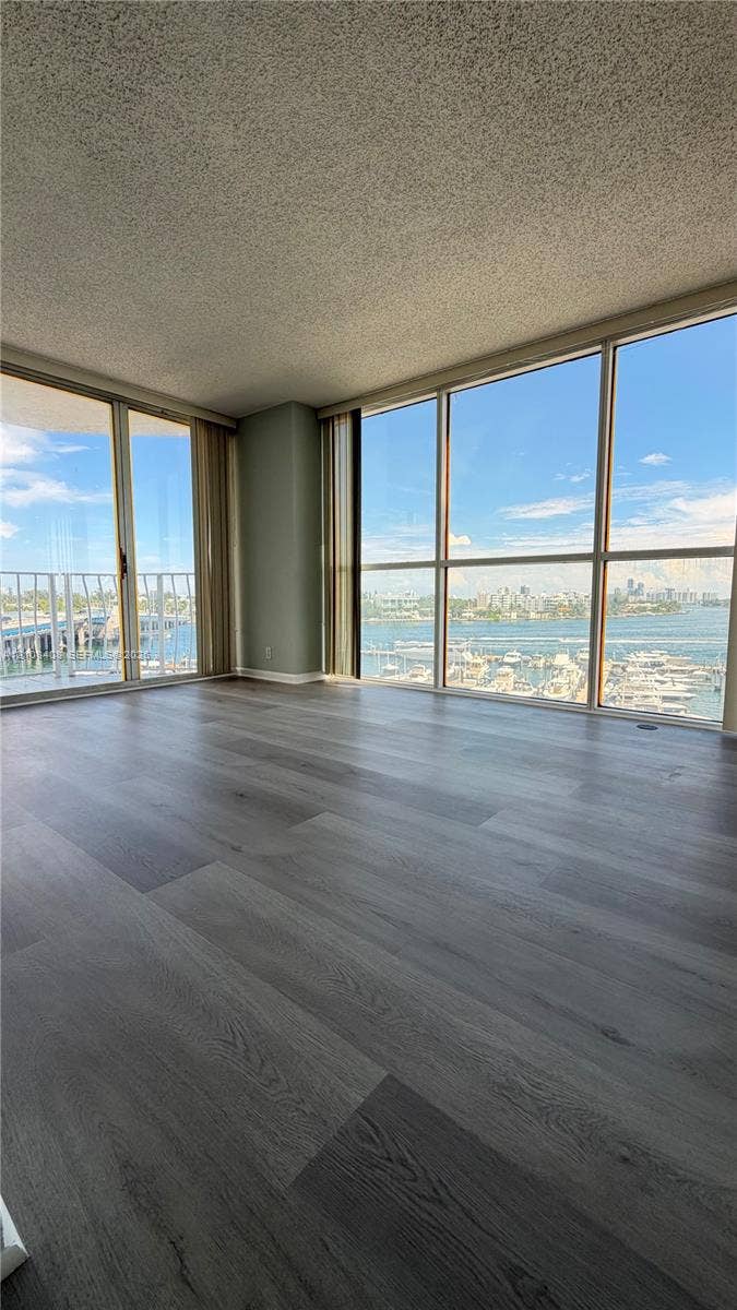 7601 E Treasure Drive, #618, North Bay Village, North Bay Village, FL 33141 Interior space featuring floor-to-ceiling windows, water-front exposure, expansive glass sliders, and wood-finish flooring
