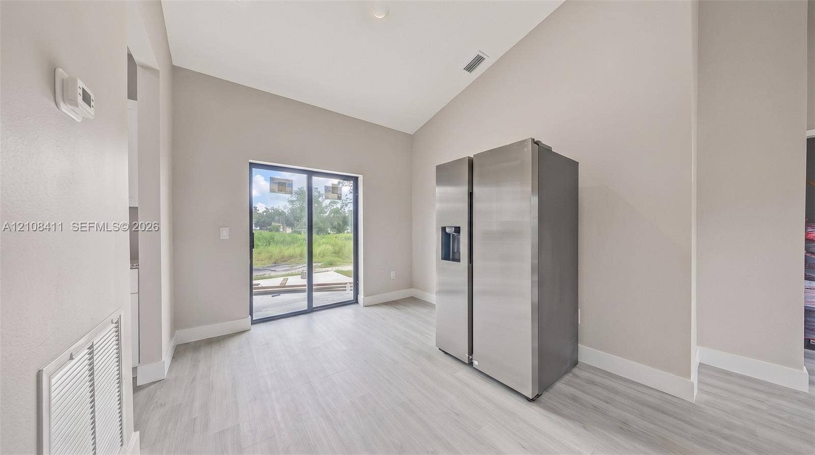 527 Avenida Del Sur, Clewiston, FL 33440 Vaulted ceilings, wood-finish flooring, and sliding glass doors providing natural light