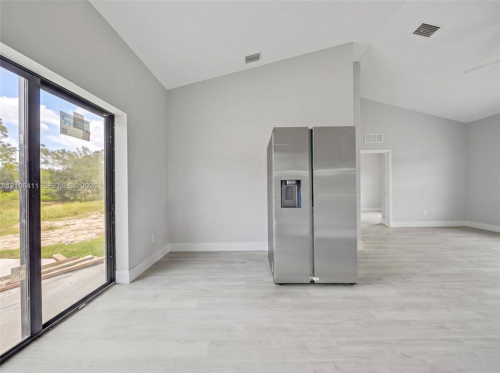 527 Avenida Del Sur, Clewiston, FL 33440 Vaulted ceilings, expansive glass sliding doors, wood-finish flooring, and a stainless steel side-by-side refrigerator