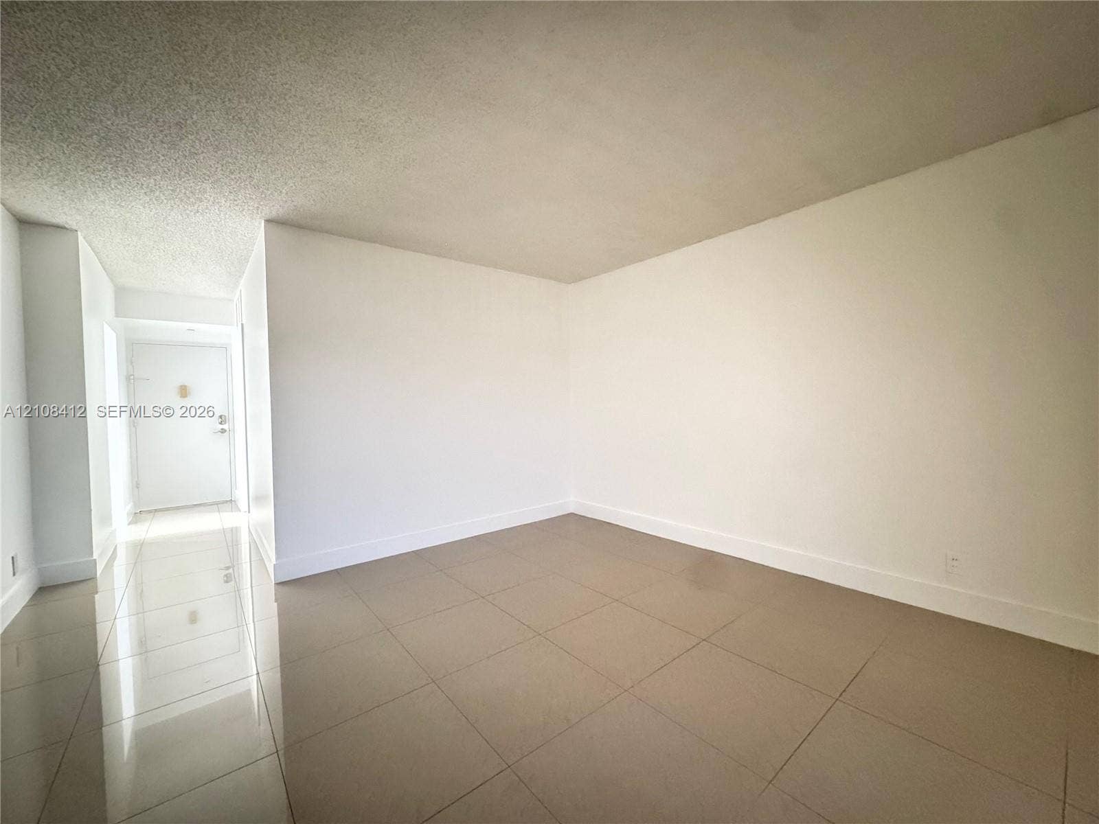Neutral-toned large-format tile flooring and white interior wall finishes