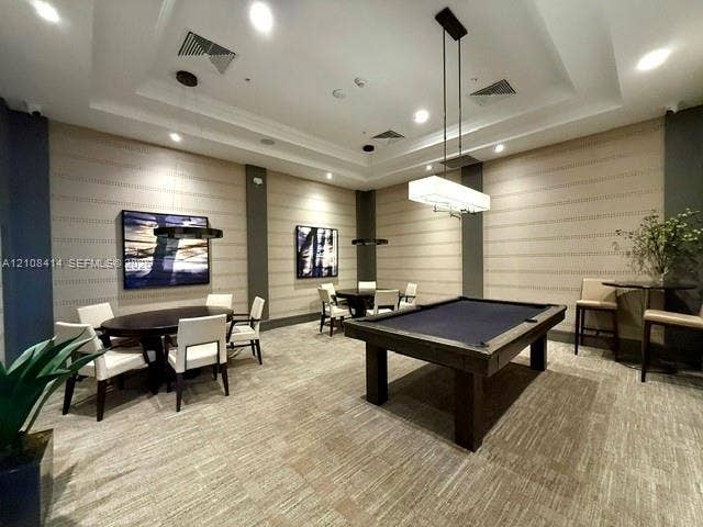 Recreation space featuring a coffered ceiling, recessed lighting, linear pendant light fixtures, and wall-to-wall patterned carpeting