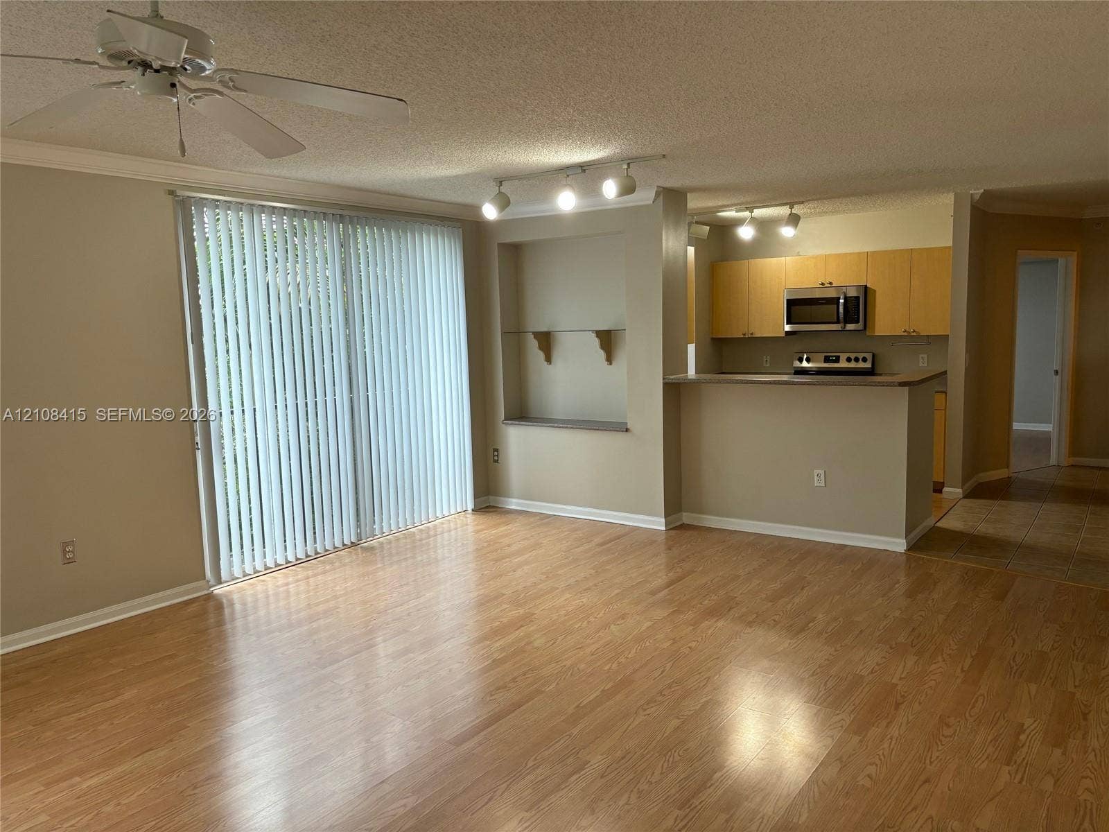 1900 Van Buren Street, #303B, Hollywood, Hollywood, FL 33020 Wood-finish flooring, sliding glass patio door, built-in recessed shelving, breakfast bar, and track lighting