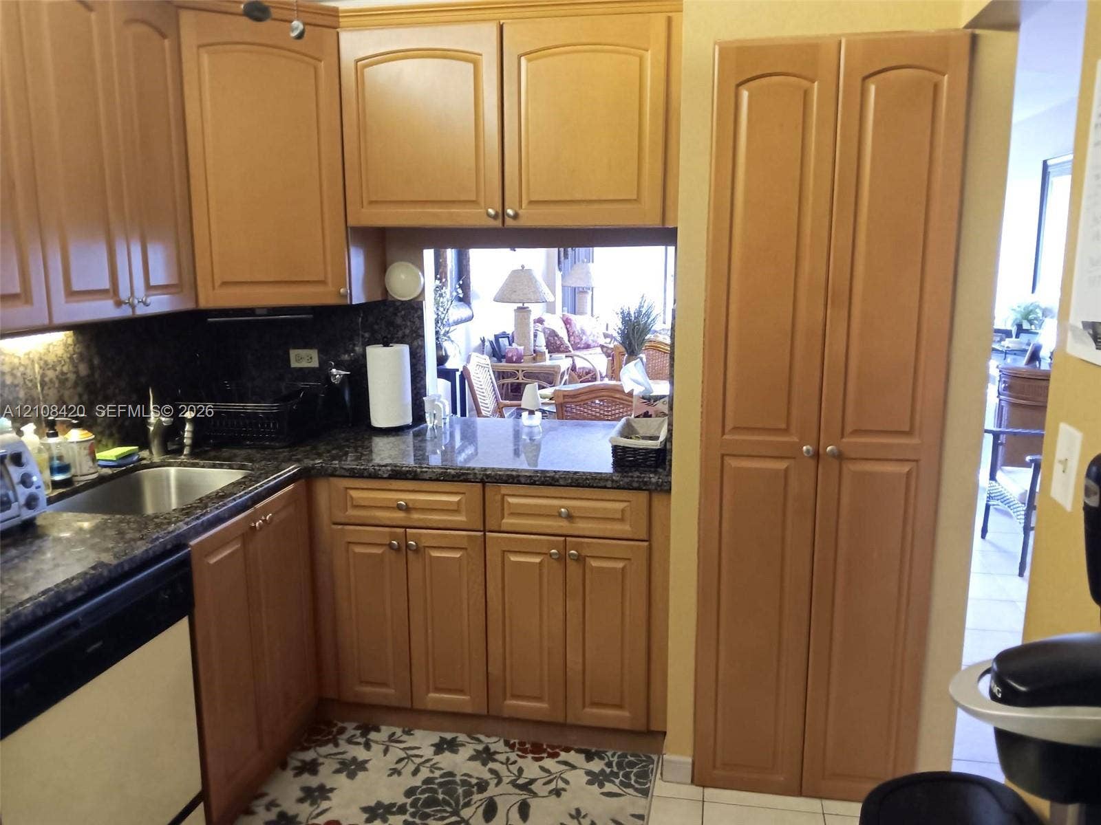 3545 NE 166th Street, #306, North Miami Beach, FL 33160 Kitchen featuring wood cabinetry, stone countertops, stainless steel undermount sink, built-in dishwasher, and a floor-to-ceiling pantry cabinet