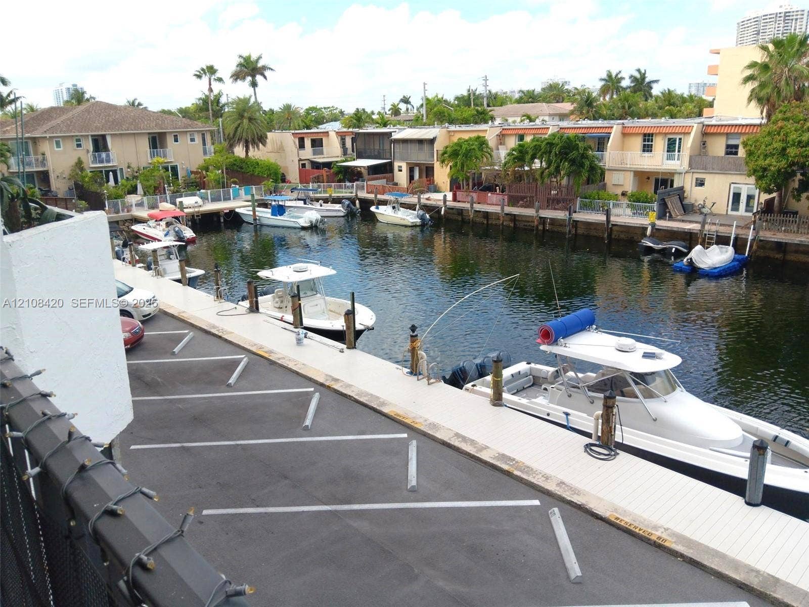 3545 NE 166th Street, #306, North Miami Beach, FL 33160 Waterfront property featuring a deep-water canal, private boat dockage, paved off-street parking, and concrete bulkhead