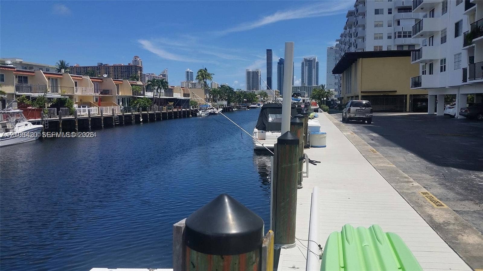 3545 NE 166th Street, #306, North Miami Beach, FL 33160 Waterfront canal bulkhead featuring dock pilings and concrete walkway