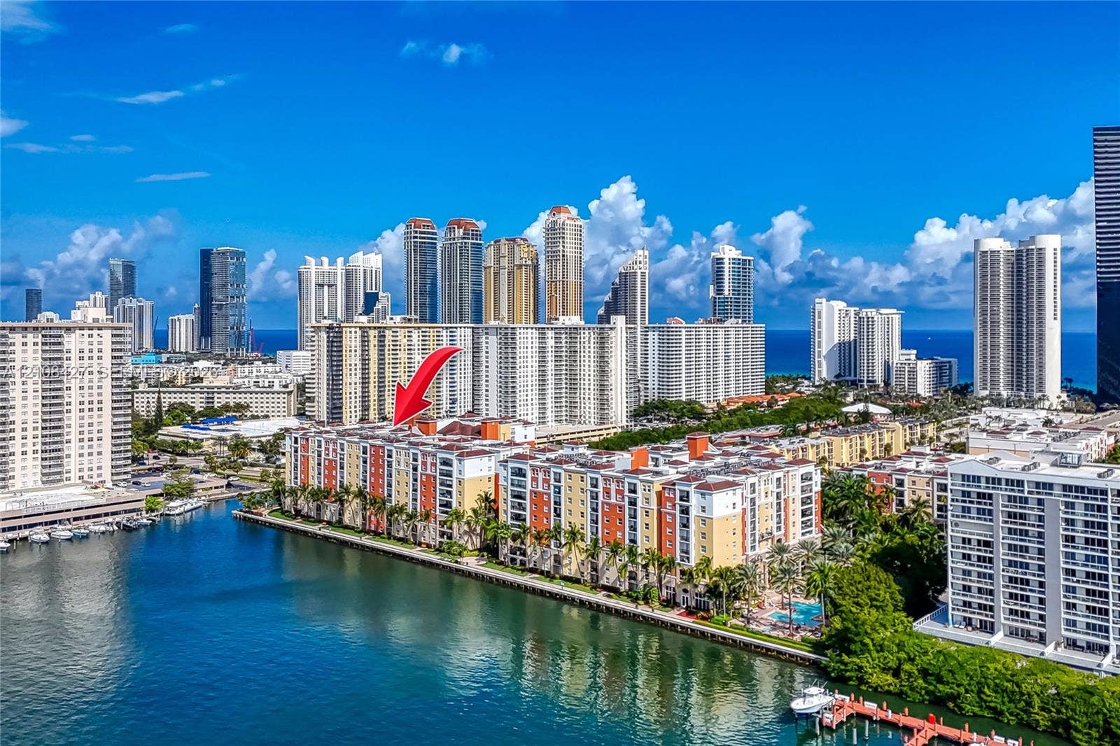Waterfront mid-rise building featuring extensive balcony square footage, a perimeter swimming pool, and direct canal frontage