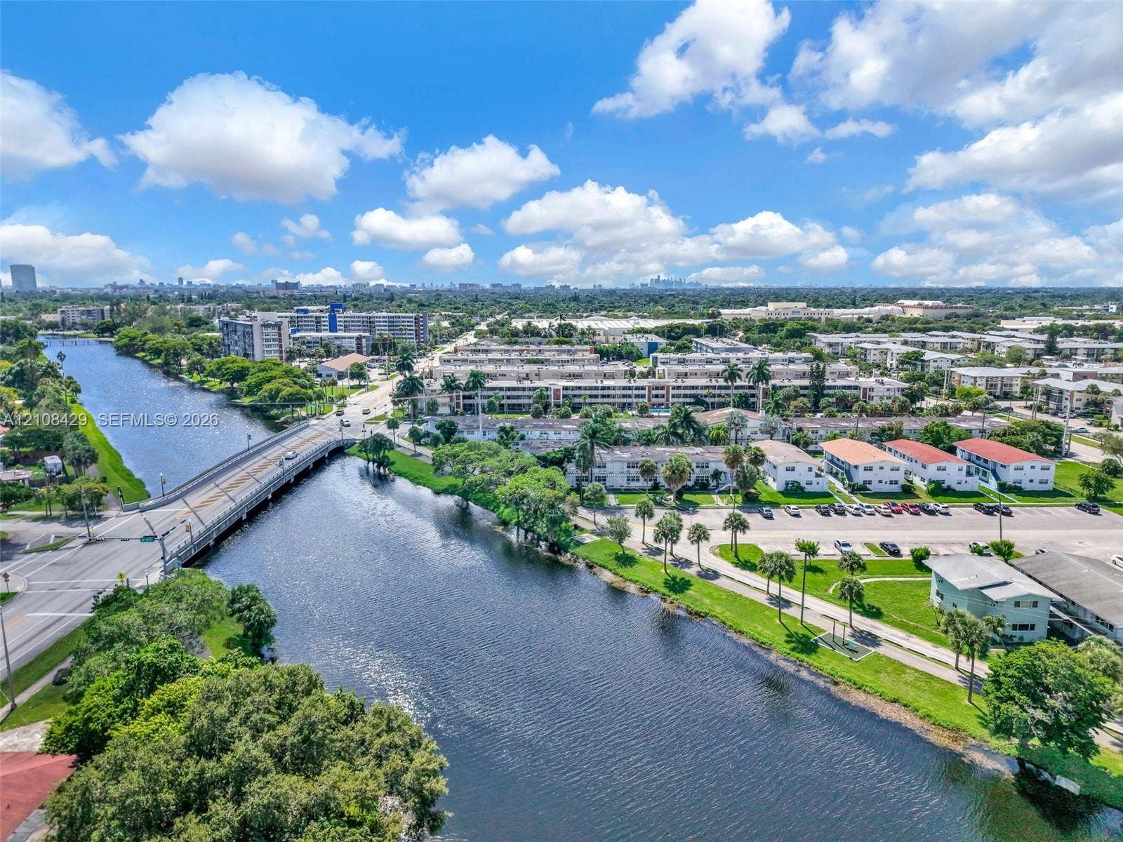 1430 NE 171st Street, North Miami Beach, FL 33162 Aerial perspective of a waterway featuring mature palm trees, landscaped green space, and proximity to infrastructure