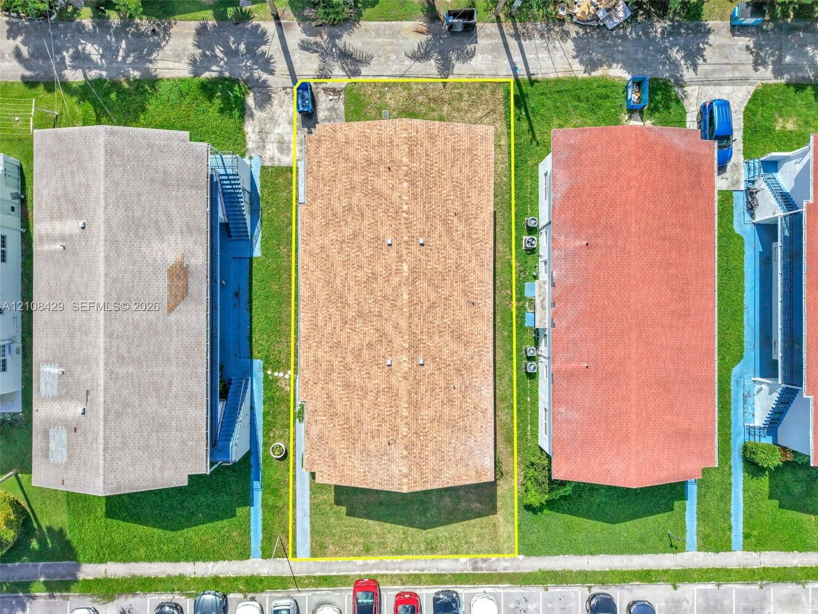 1430 NE 171st Street, North Miami Beach, FL 33162 Aerial perspective of property lot featuring asphalt shingle roof, grass-covered grounds, and paved driveway access
