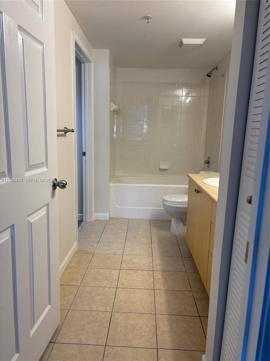 1919 Van Buren Street, #219A, Hollywood, FL 33020 Bathroom featuring tile flooring, a tub-shower combination with full-height tile surround, and a wood-finish vanity cabinet with a drop-in sink